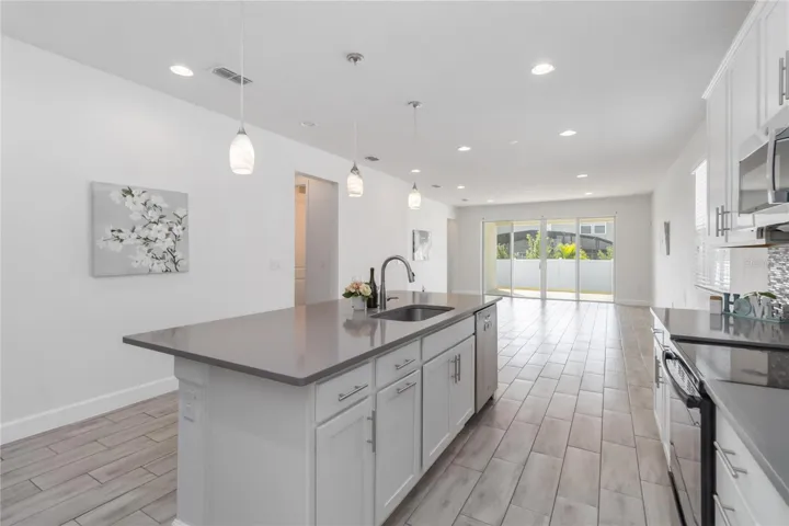 Large kitchen/dining/living space with tile floors and Quartz counters