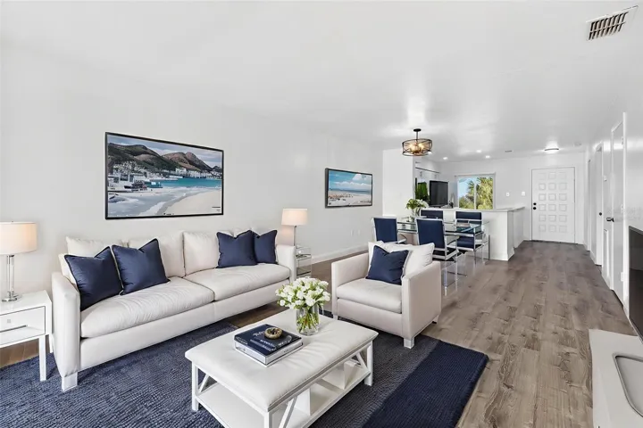 Virtually Staged. Lightly-filled, open-concept living with luxury vinyl flooring and Gulf views through impact windows. Sophisticated and supremely livable.