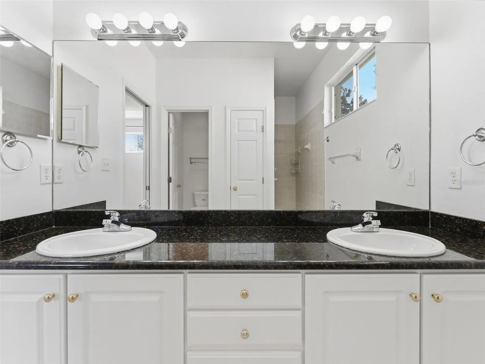 Primary bath with dual sinks and large walk-in shower, linen closet and private water closet