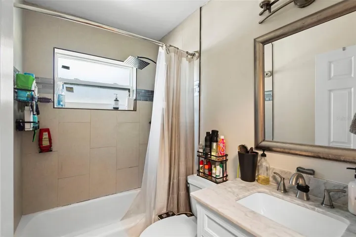 View of bathroom with tub and shower.