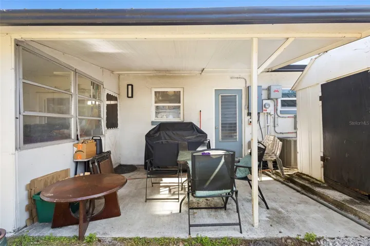 View of outside of patio, entrance of laundry room with shed for storage.