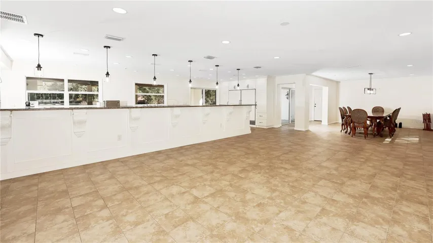 Living Room looking Towards Kitchen and Dining Room!  | •This Home is the Last Word in finding the Sought-After OPEN FLOORPLAN with a Gourmet Kitchen with a Breakfast Bar longer than you find in Restaurants Overlooking a Cavernous Family Room and Dining Room…and then another Bonus Separate Living Room with a Floor-to-Ceiling Brick Fireplace!