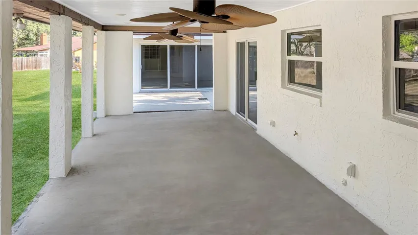 Huge, House-Length Back Porch as seen from the Bonus Family Room!  | Family and Guests can then easily Step outside to the House-Length BACK PORCH with both Covered and Uncovered Area Overlooking a FENCED, Tree-Filled Backyard so Long You will need Binoculars to see the end of it!