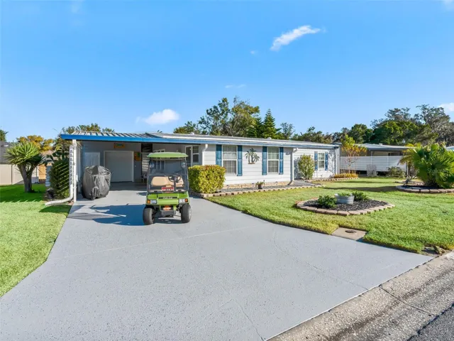 Beautifully remodeled 2/2 home.  Upgraded landscaping, painted driveway, one car garage and a large carport.  Cute golf cart included to cruise around the neighborhood or head to the clubhouse and pool!