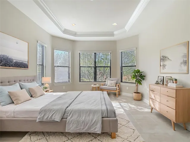 Virtually staged primary bedroom with tray ceiling and crown molding