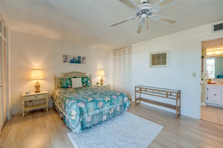 Another view of the primary bedroom highlights the serene layout, generous storage, and en suite bathroom access.