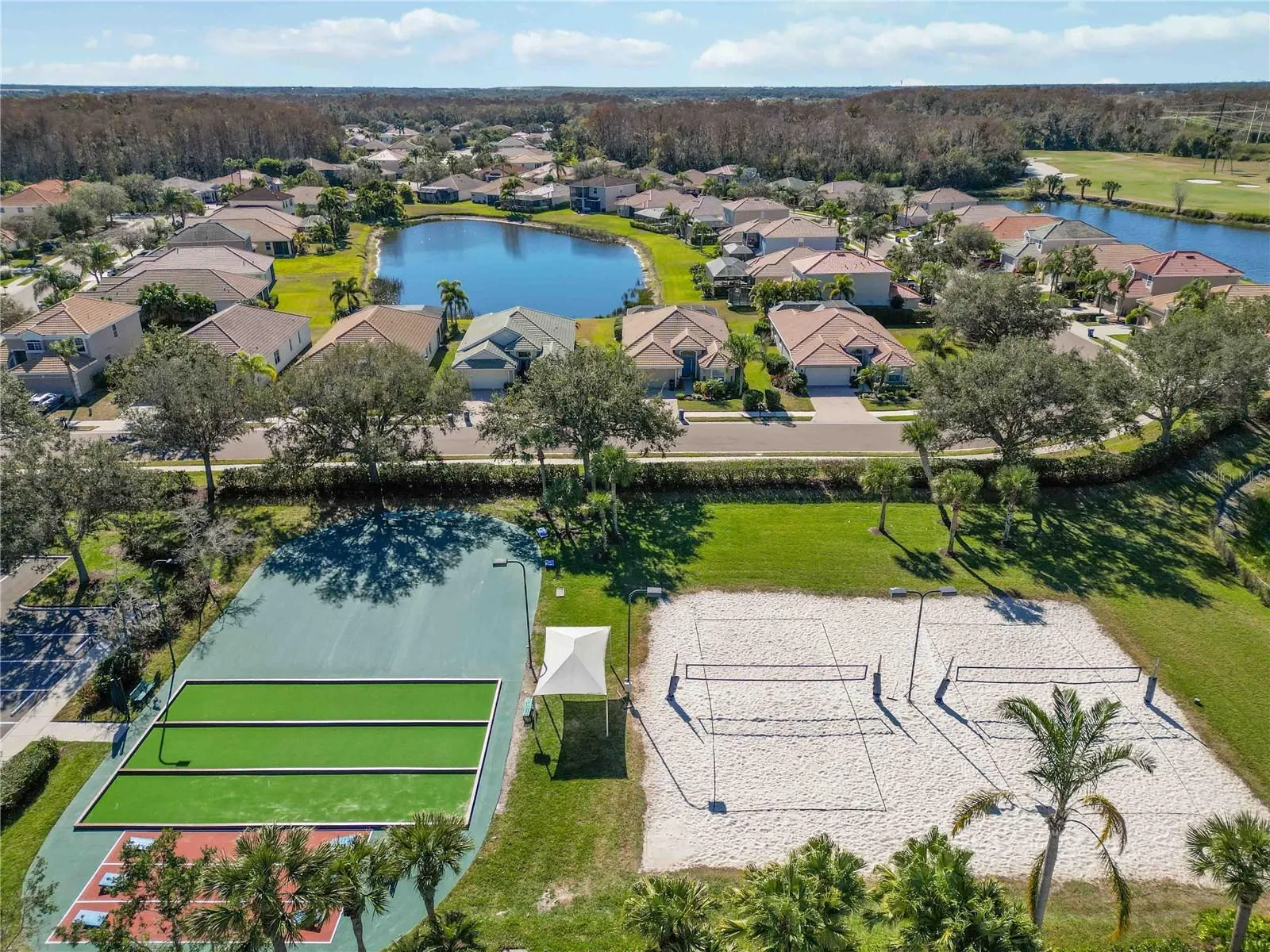 Cornhole, Bocce courts, table area, and lighted sand volleyball courts