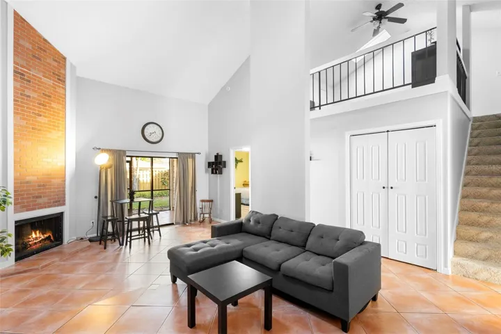 Living room with loft above. Fireplace is showing a virtual flame.