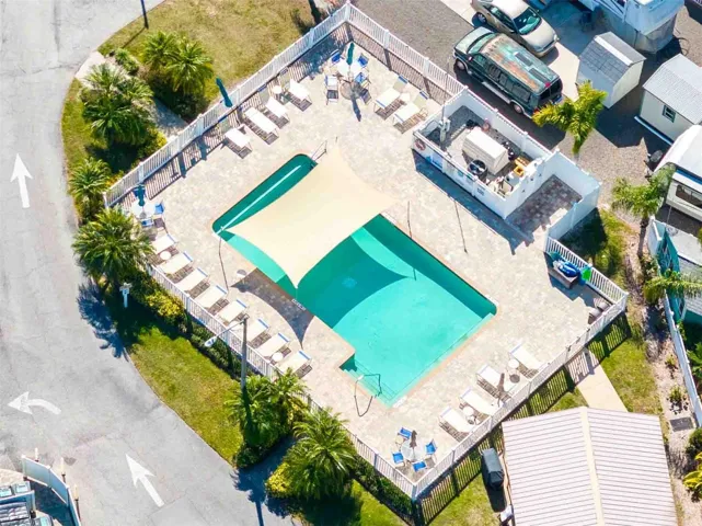 Super cool pool with a shade canopy.  Building to the left is the picnic area with lots of tables.