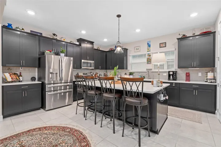 A Great Kitchen with Upgraded Cabinets, Island, Breakfast Bar, Quartz Counters and A Large Walk in Pantry.