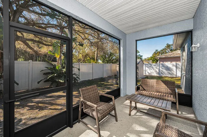 Screened-in patio opens to a large and partially shaded backyard. Completely fenced too!