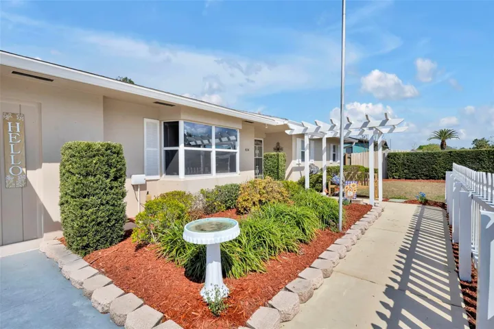Fenced front walkway to the front door with view of beautiful bay window.
