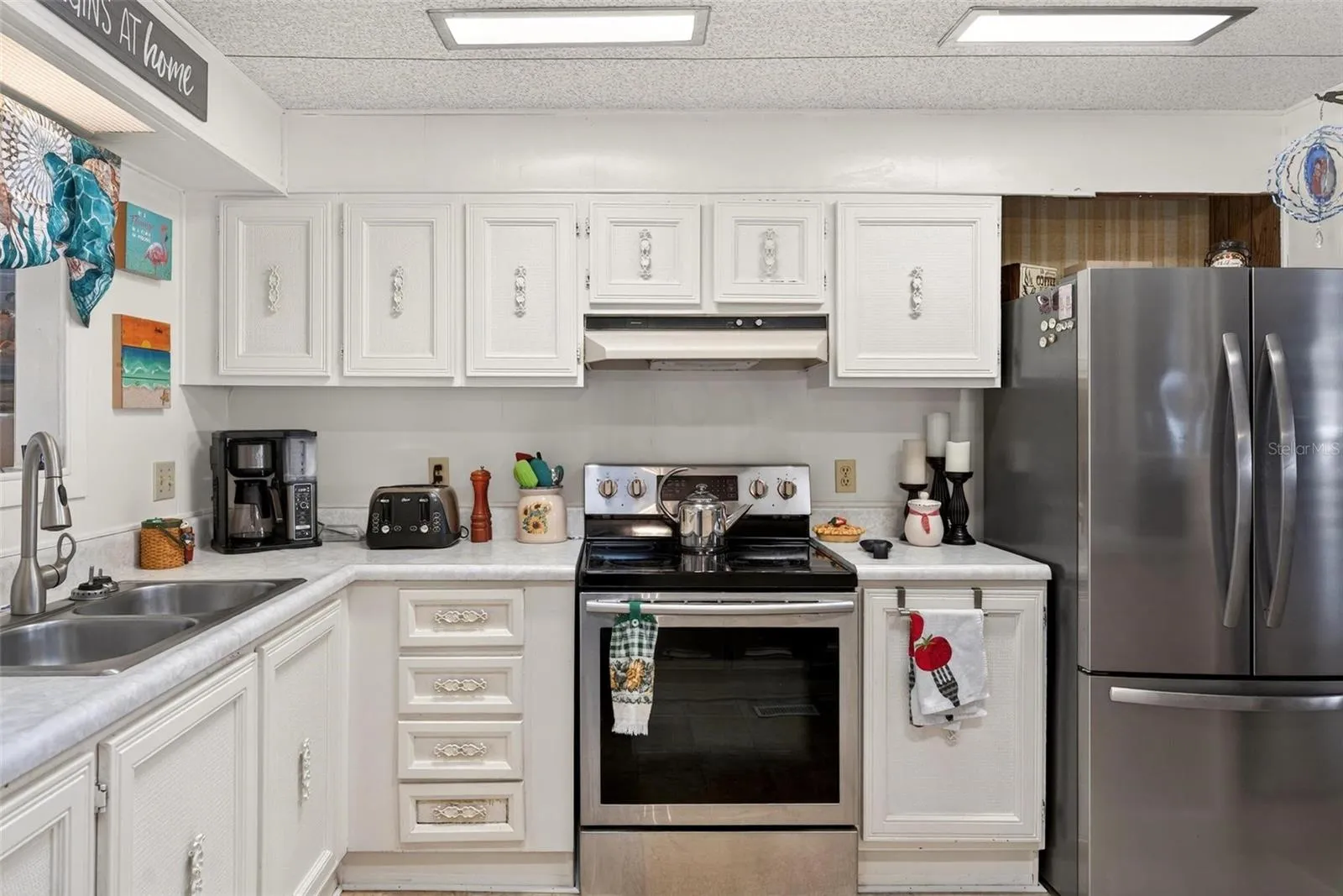 Kitchen with stainless steel range and refrigerator