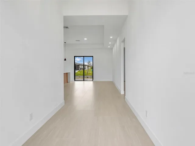 Hallway with recessed lighting and baseboards