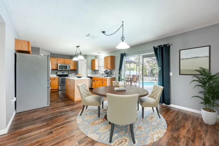 Dining area overlooks the lanai and pool. Virtually Staged.