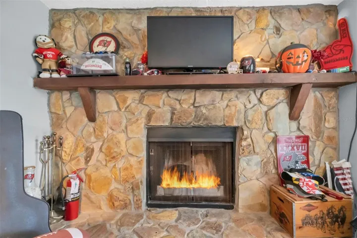 Large Florida room/Sun room with a fireplace at one end. This room in located on the canal side and continues to the screened in porch area.