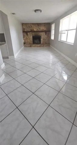 Large Florida room/Sun room with a fireplace at one end. This room in located on the canal side and continues to the screened in porch area.