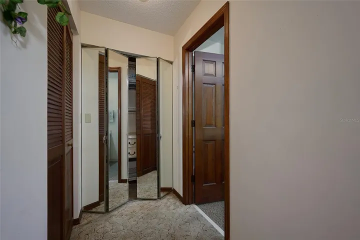 PRIMARY BEDROOM HALLWAY TO WALK-IN CLOSET, LINEN SPACE AND FULL BATH WITH WINDOW