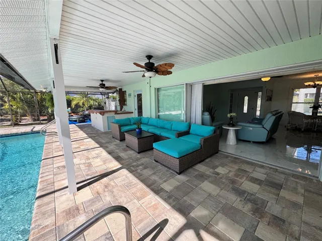 Spacious covered patio on pool deck with outdoor kitchen