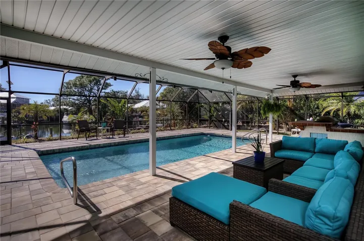 Spacious covered patio on pool deck with outdoor kitchen