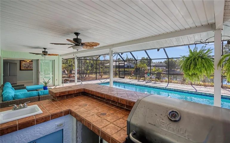 Spacious covered patio on pool deck with outdoor kitchen