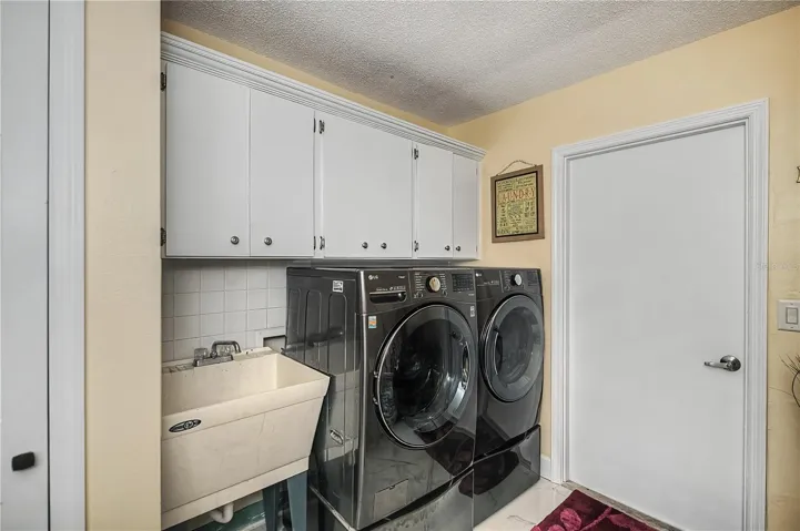 Inside laundry room with storage and utility sink