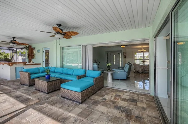 Spacious covered patio on pool deck with outdoor kitchen