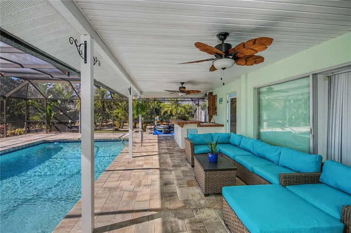 Spacious covered patio on pool deck with outdoor kitchen