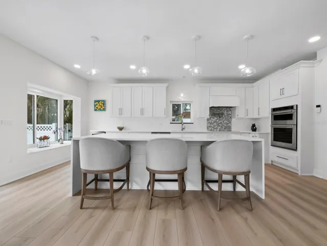 The entirely NEW coastal kitchen with a large island and views to the gorgeous backyard oasis