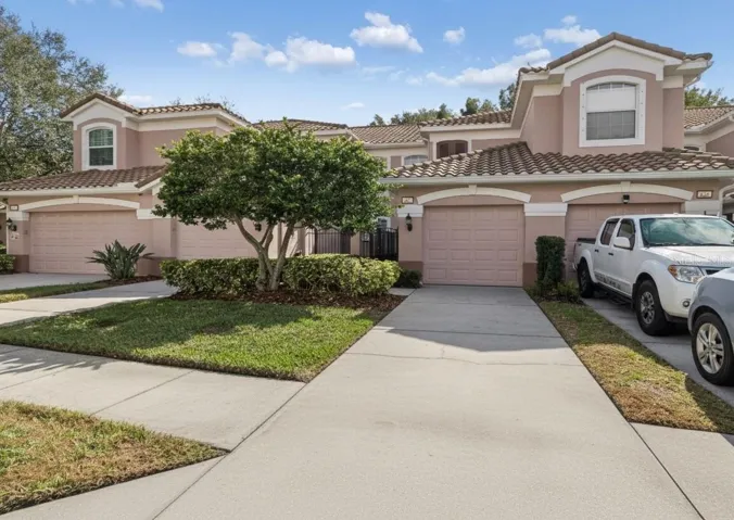 The front of the home includes a private garage and well-maintained landscaping, nestled in a peaceful, tree-lined community.