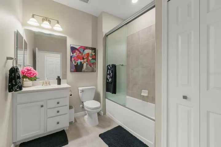 Guest bathroom with shower/tub combo and glass door.