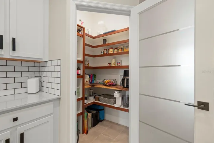 Fully upgraded pantry with custom shelving and custom frosted glass door.