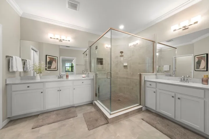 Primary bathroom with separate sinks and large walk-in shower.