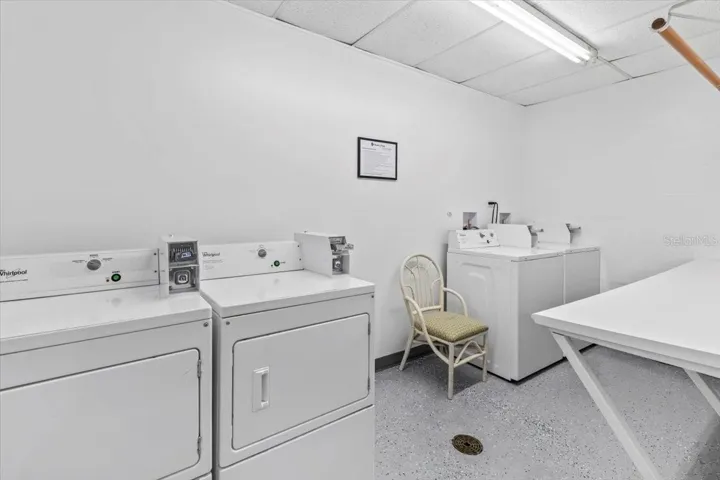 Bright and clean on-site laundry room featuring commercial-grade Whirlpool washers and dryers, ample folding space, and easy-access layout for residents’ convenience.