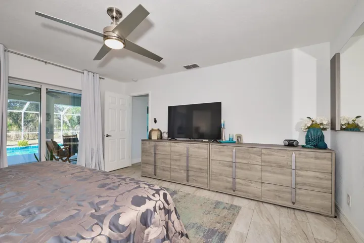 primary bedroom with sliders to lanai/pool area