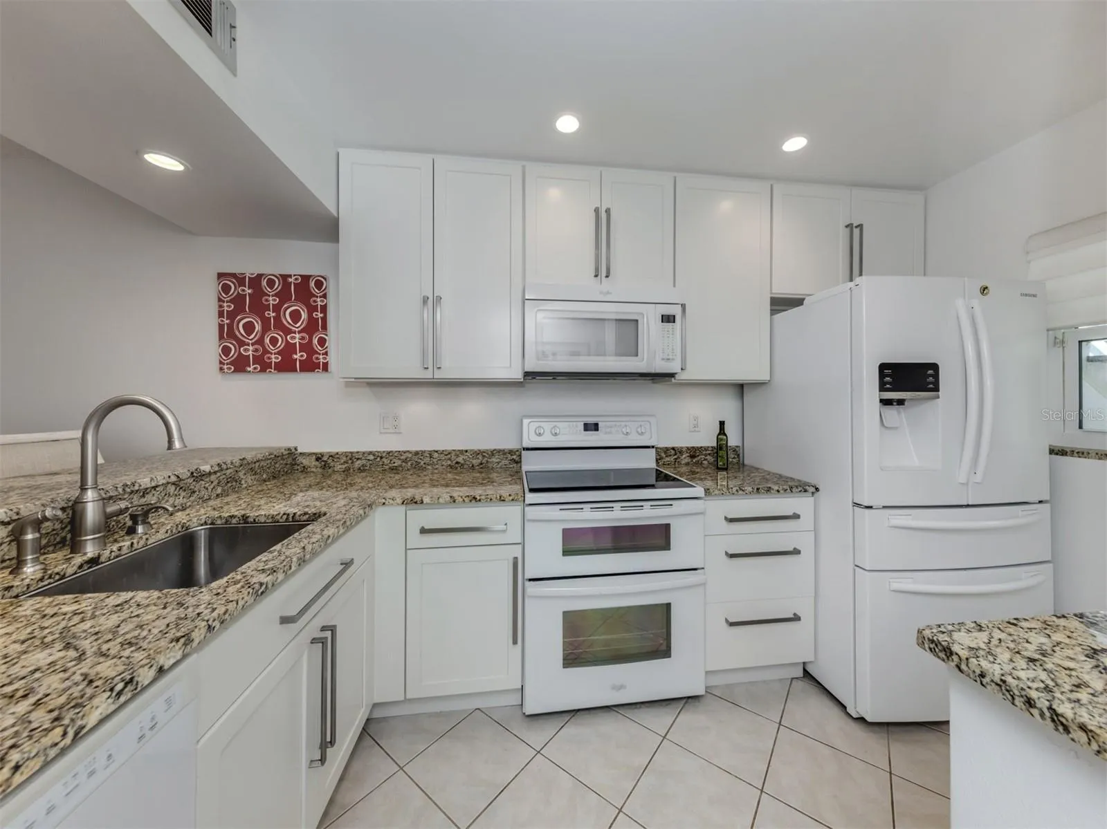 Updated kitchen with wood cabinetry and granite countertops