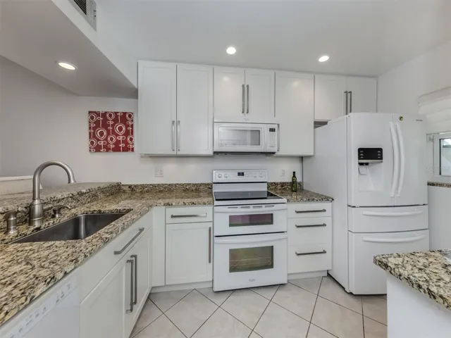 Updated kitchen with wood cabinetry and granite countertops