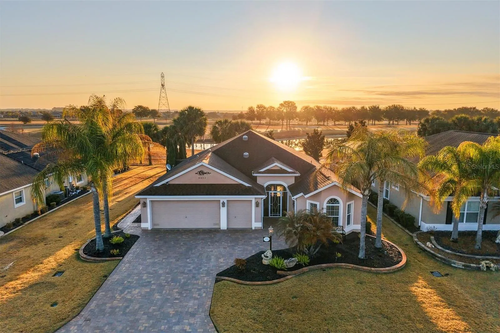 Stunning curb appeal with detailed landscaping, architectural accents, and paver driveway on this 3 bedroom/2 bathroom Begonia Designer home in The Villages FL near Belle Glade Championship Golf Course.