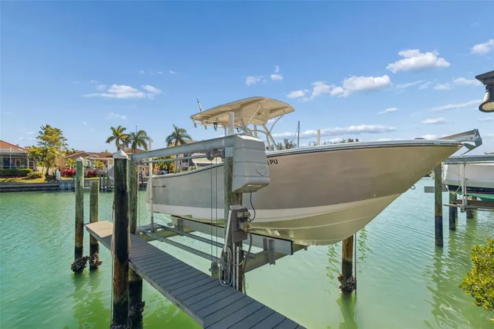 Deeded boat slip with 10,000-lb lift on a protected canal, offering quick access to open water — perfect for boating, fishing, and effortless waterfront living. From that slip owners have caught sweeps head, snook, red fish and other delicious fish. Fish cleaning table conveys.