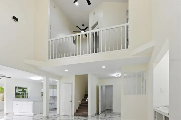 View into kitchen, entryway, and upstairs from family room