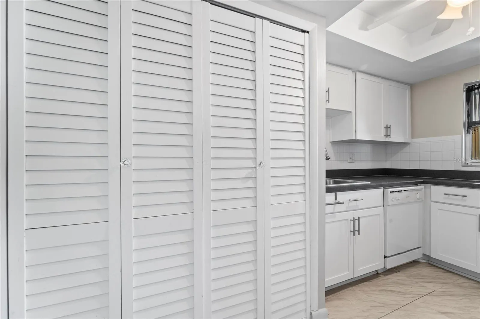 Kitchen area with the closet doors covering the storage area and the washer and dryer