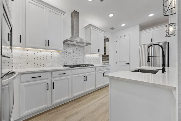 Open-concept kitchen featuring Smart LG appliances, farmhouse sink, gas cooktop, and seamless flow into the main living area.