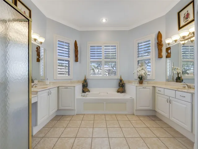A spa-inspired en suite bath boasts a soaking garden tub, two separate oversized vanities, a step-in shower, and a private water closet.