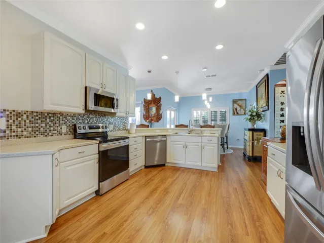 At the heart of the home is the beautifully appointed Kitchen, featuring crisp white cabinetry, QUARTZ COUNTERTOPS, a stylish backsplash, breakfast bar seating, and a sunny EAT-IN AREA overlooking the backyard and tranquil pond.