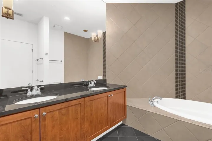 Primary bath with dual vanity, tub, and shower.