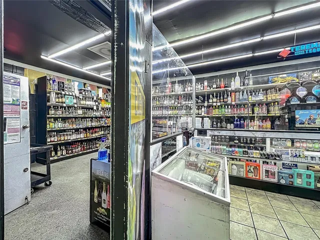 Secure Glass-Enclosed Sales Counter with Controlled-Access Door and Premium Liquor Display