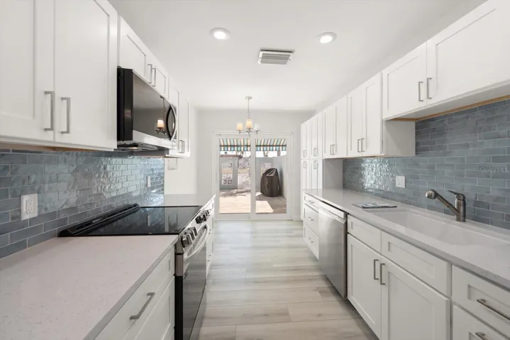 Kitchen with sliders out to front patio with grill station