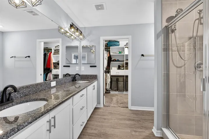 Primary Bathroom features double sink vanity with granite counter top and large walk in shower.