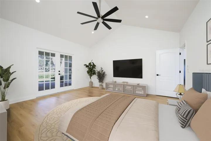 Primary Suite with French doors to covered lanai overlooking golf course.
