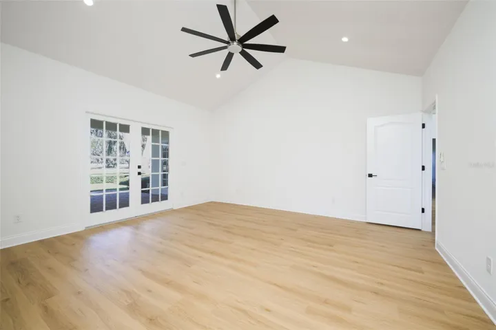 Primary Suite with French doors to covered lanai overlooking golf course.